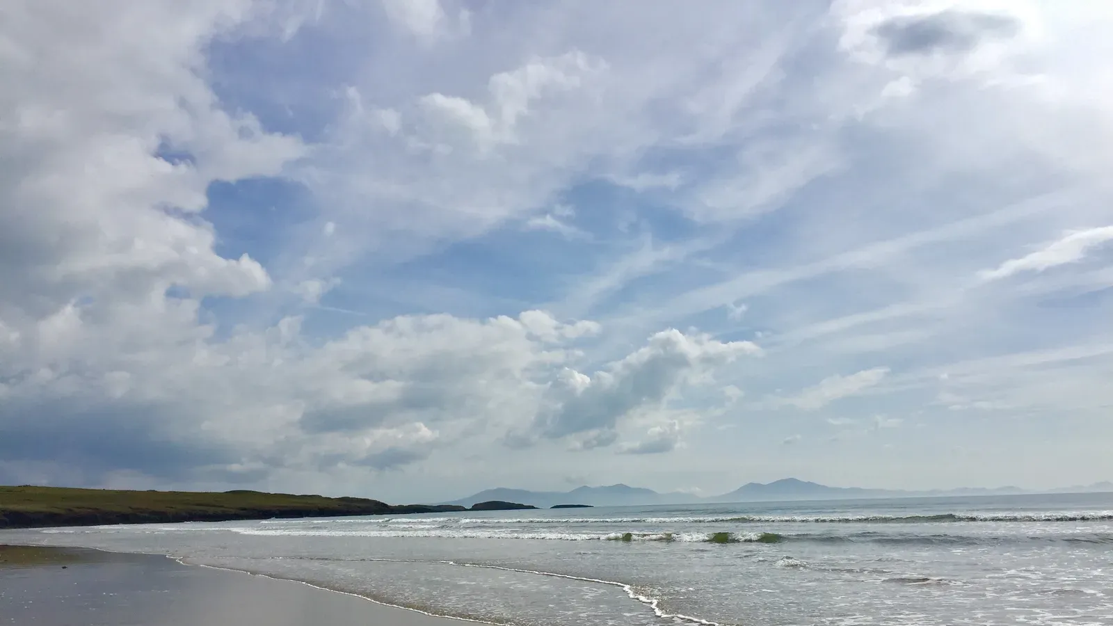 Aberffraw Beach at low tide on Anglesey, with the mainland mountains of the Llŷn Peninsula across the water