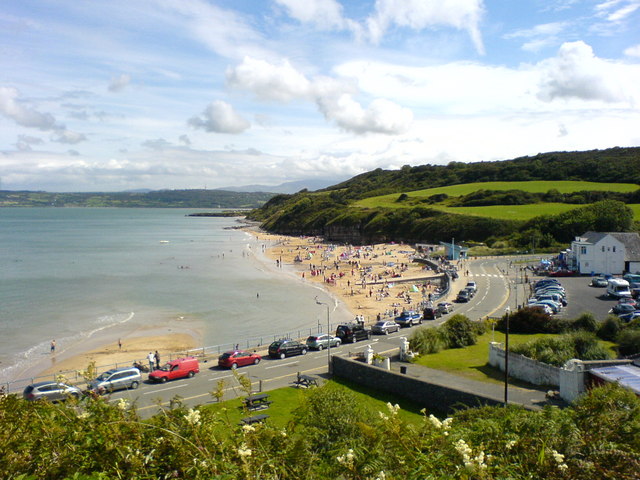 Golden sandy beach at Benllech on Anglesey's east coast with low cliffs and blue summer skies