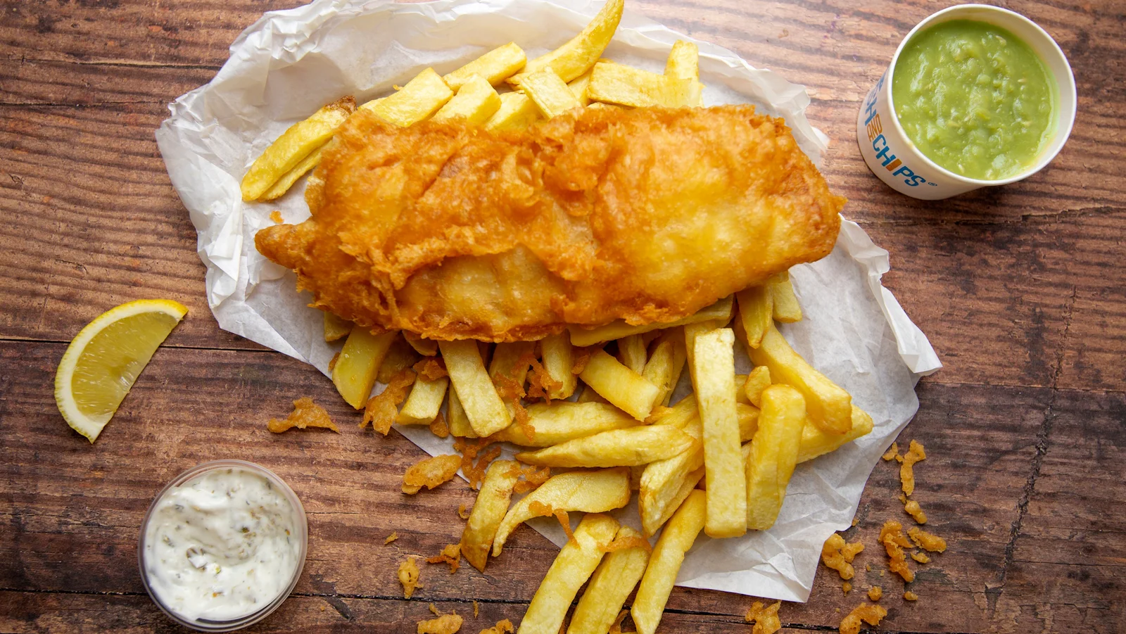 Mermaid Fish Bar in Benllech with queues outside on a summer day and the beach behind