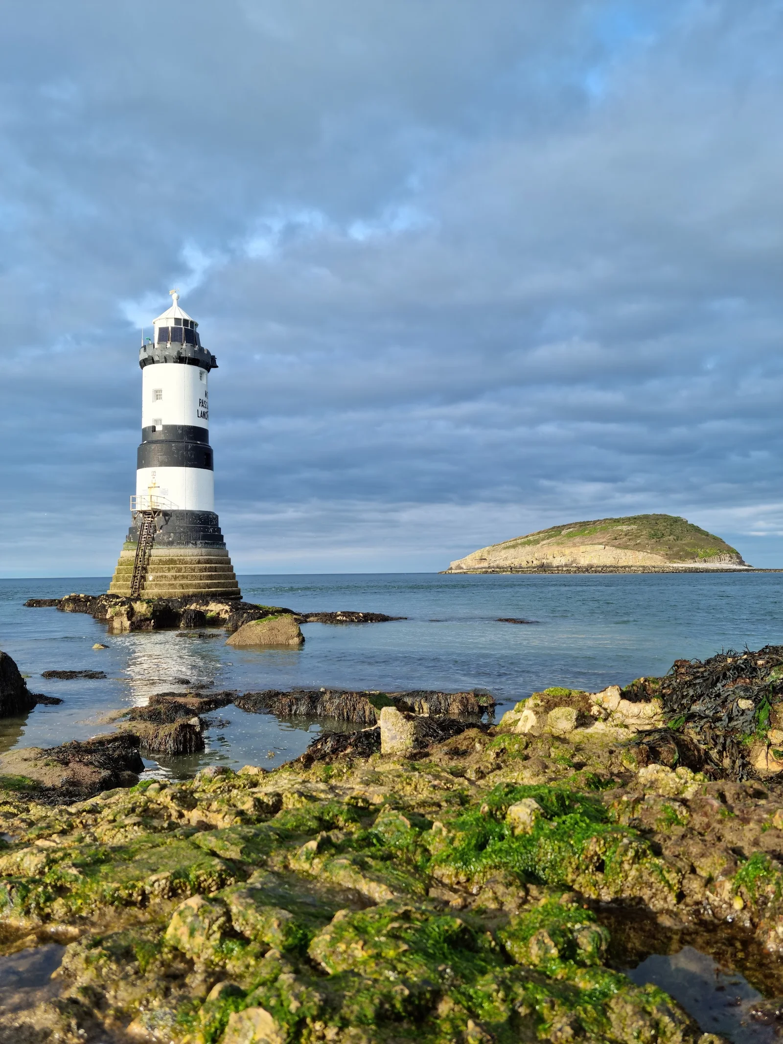 Penmon Point lighthouse with Puffin Island just offshore and the Menai Strait in the background