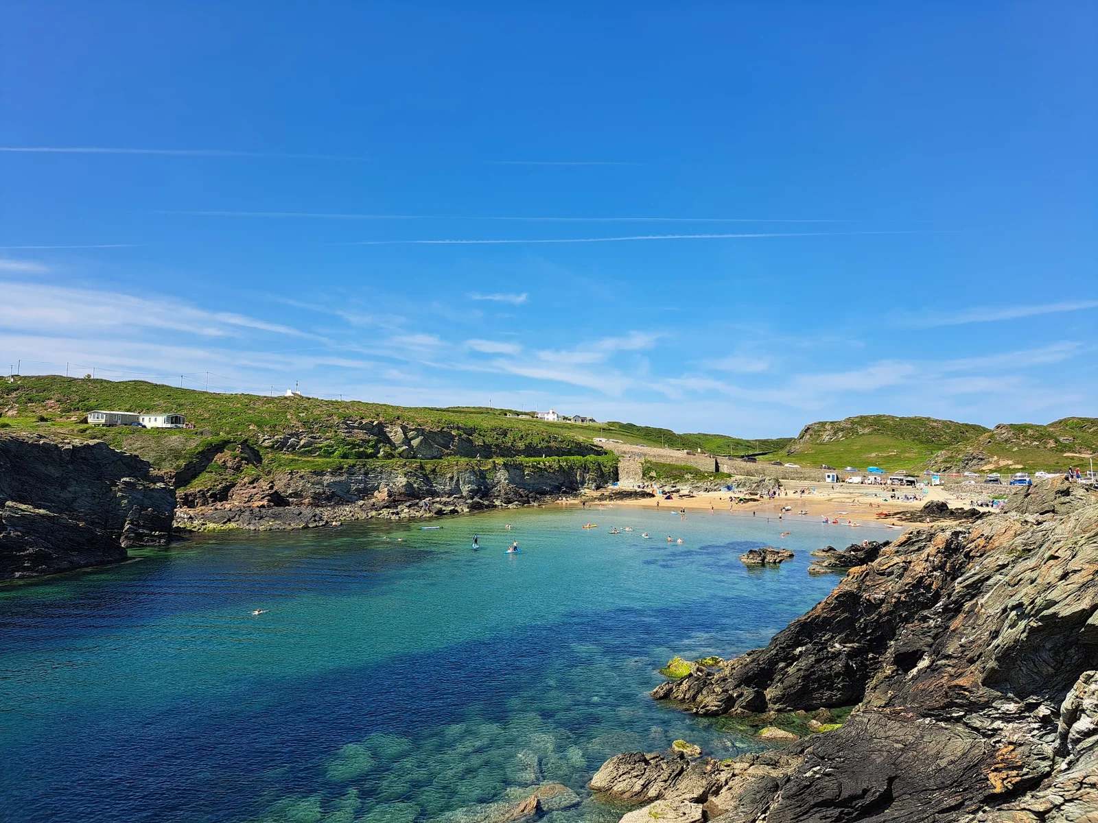 Porth Dafarch horseshoe cove on Holy Island with clear turquoise water and rocky headlands