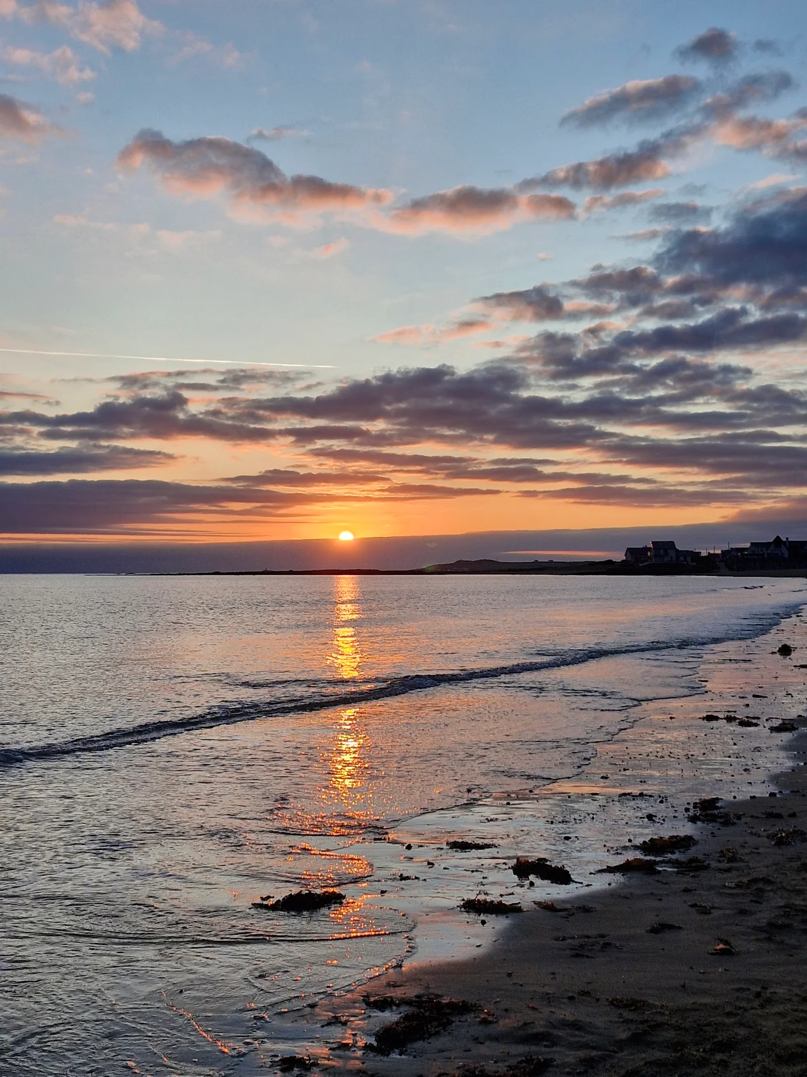 Rhosneigr beach Anglesey west coast with kitesurfers riding the Atlantic swell under dramatic skies