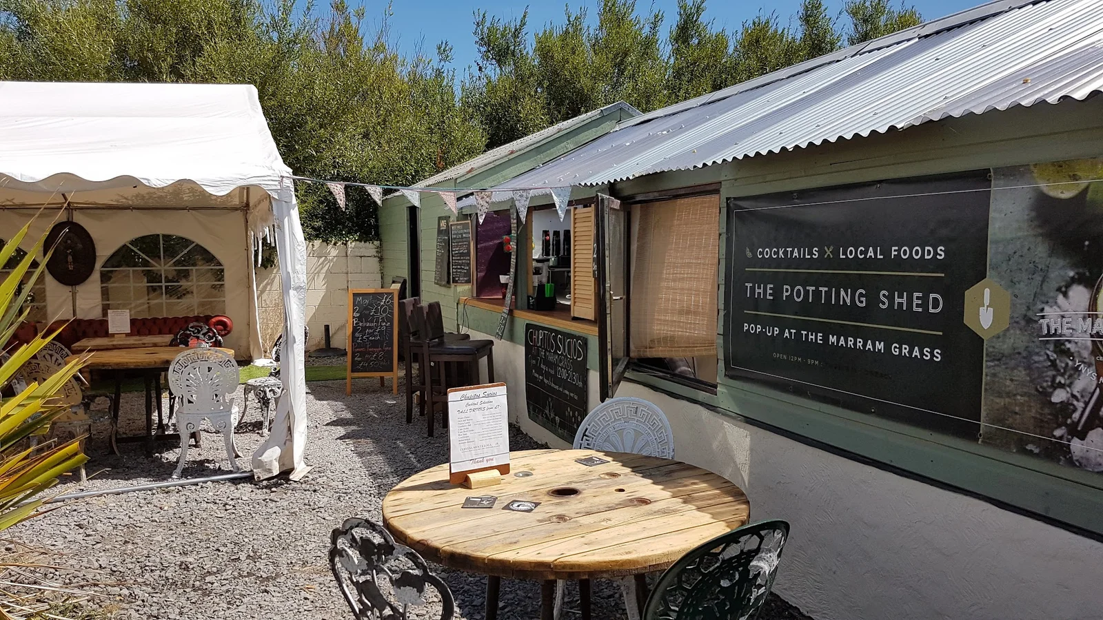 The Marram Grass kitchen garden in summer with the converted farmhouse restaurant behind, near Newborough
