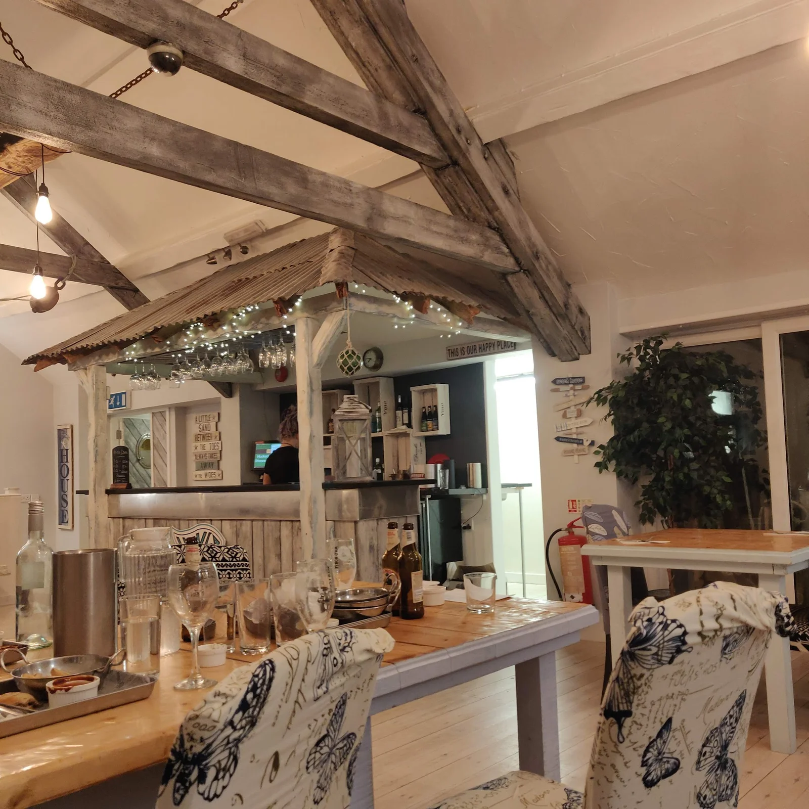The Reef surf café at Rhosneigr beach with the Atlantic and kitesurfers behind